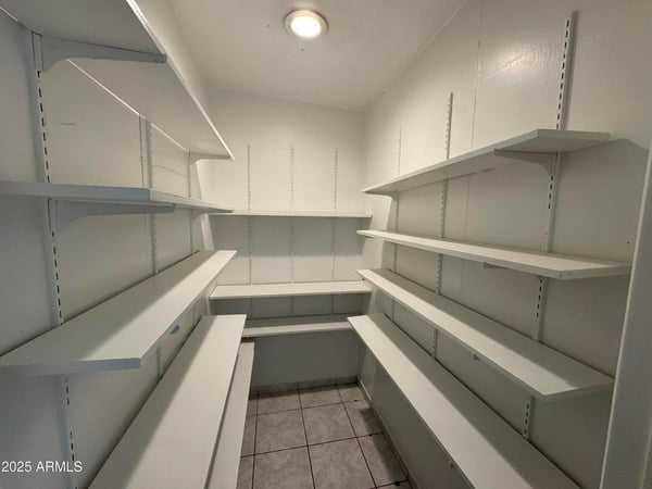 Oversized walk-in pantry with wall-to-wall shelving and dedicated storage areas for kitchen essentials. This desirable feature adds convenience, organization, and valuable storage capacity for everyday living.