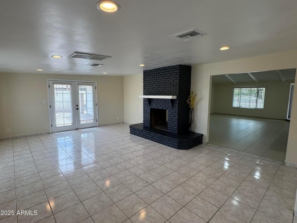 Inviting family room highlighted by a bold two-way fireplace, backyard access, and generous living space. The open design makes this area ideal for relaxing or hosting family and friends.