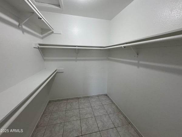 Generously sized walk-in closet featuring extensive hanging space, shelving, and room for organized storage. Ideal for keeping wardrobes and personal items neatly arranged.