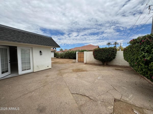 Open patio space offers a welcoming environment for outdoor gatherings, grilling, or relaxing evenings. Privacy walls and established landscaping create an enjoyable extension of the home's living space in Glendale.