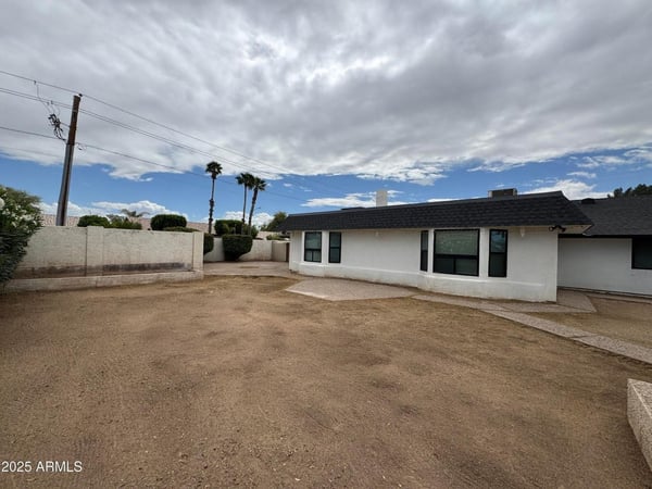 Expansive backyard with desert-friendly landscaping and multiple outdoor seating opportunities. The generous lot size provides flexibility for pets, play, gardening, or future customization.