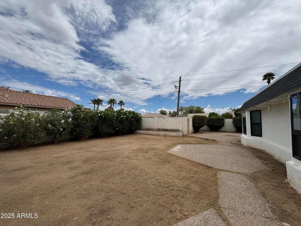 Attractive backyard retreat featuring mature landscaping, privacy fencing, and spacious grounds. The combination of patio surfaces and open yard space creates excellent potential for outdoor enjoyment and entertaining.