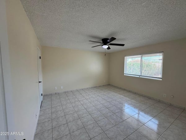 Well-appointed bedroom with generous dimensions, tile flooring, and natural light. Perfect for guests, family members, or creating a productive work-from-home environment.