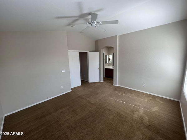 Enjoy a spacious primary bedroom featuring soft carpeting, vaulted ceilings, and direct access to the ensuite bathroom. The generous size creates a relaxing retreat at the end of the day.