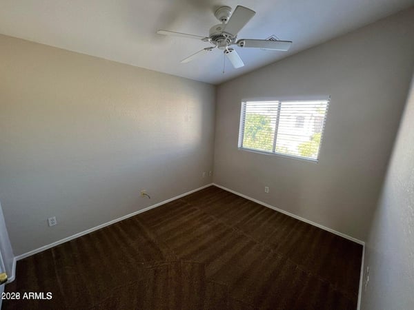This comfortable bedroom features a large picture window, ceiling fan, and neutral design palette. The flexible layout is ideal for a variety of living arrangements and lifestyle needs.