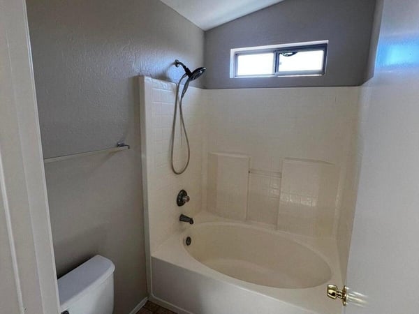 Featuring a tub and shower combination, tile flooring, and natural light, this bathroom offers practical functionality for family members and guests alike.