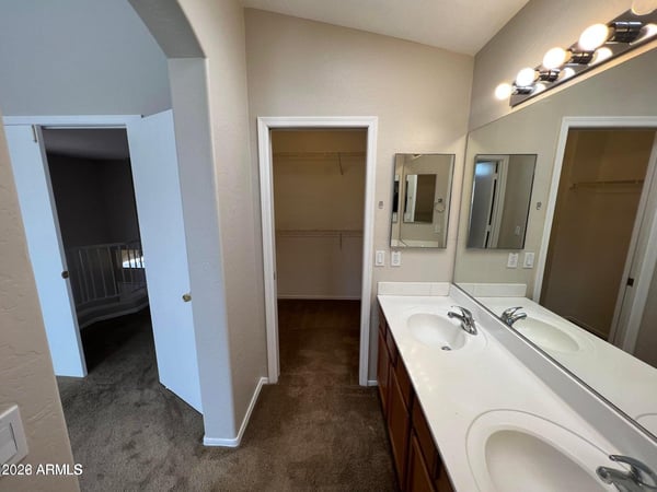 Dual vanities, generous counter space, and easy access to the walk-in closet create a highly functional primary bathroom. The thoughtful design enhances comfort and daily convenience.