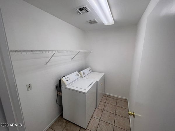 Dedicated laundry space with included appliances, storage shelving, and room for household organization. A valuable feature that helps simplify everyday living.