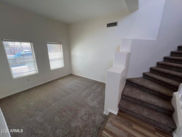 A bright and flexible room with plush carpeting and large windows offers endless possibilities. Ideal for a home office, reading room, study area, or additional living space.