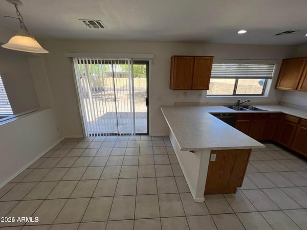 Sliding glass doors bring natural light into this spacious dining area and kitchen. Easy backyard access enhances Arizona indoor-outdoor living and entertaining opportunities.