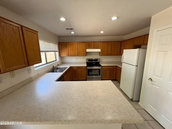 Designed for functionality, this kitchen offers extensive countertops, abundant cabinetry, and recessed lighting. The spacious peninsula provides additional prep space and room for casual seating.