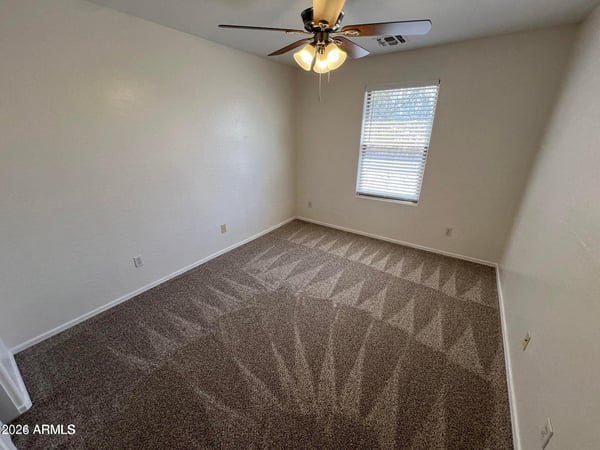 Spacious bedroom with plush carpeting, neutral finishes, and a comfortable layout suitable for guests, family members, hobbies, or a home office.