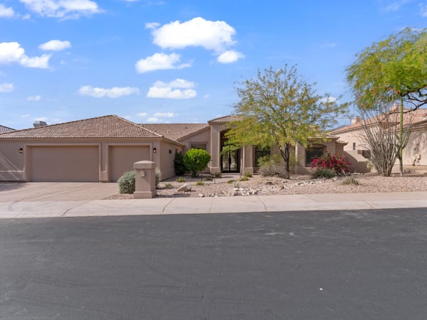 Wide front elevation displaying elegant architecture, generous driveway, and attractive desert landscaping. This beautifully updated Scottsdale residence combines modern luxury with timeless exterior design.