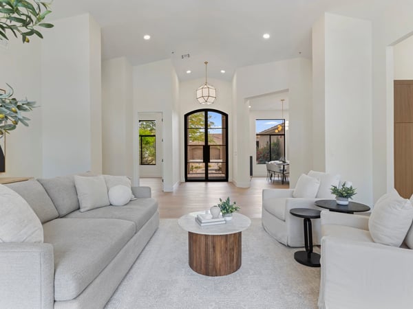Spacious living room featuring high ceilings, abundant natural light, wide-plank flooring, and modern finishes. The open design creates a warm and comfortable setting for everyday living.