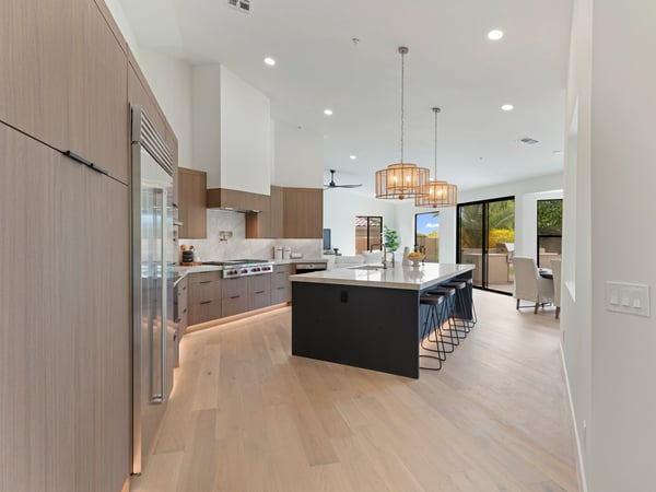 Stunning gourmet kitchen with premium Wolf and Sub-Zero appliances, a large waterfall island, custom cabinetry, and designer lighting. The open layout creates the perfect space for entertaining and everyday living in Scottsdale.