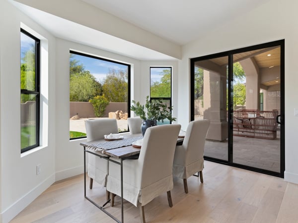 Sunny breakfast area with oversized windows and sliding glass doors overlooking the covered patio and backyard. A perfect spot to enjoy casual dining while embracing Scottsdale's indoor-outdoor lifestyle.