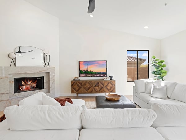 Inviting living room featuring a sleek fireplace, modern finishes, and expansive windows that fill the space with natural light. An ideal setting for relaxing or entertaining guests.
