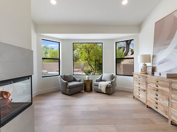 Relaxing lounge area with backyard views, large picture windows, and a contemporary fireplace. This inviting extension of the primary suite offers both elegance and versatility.