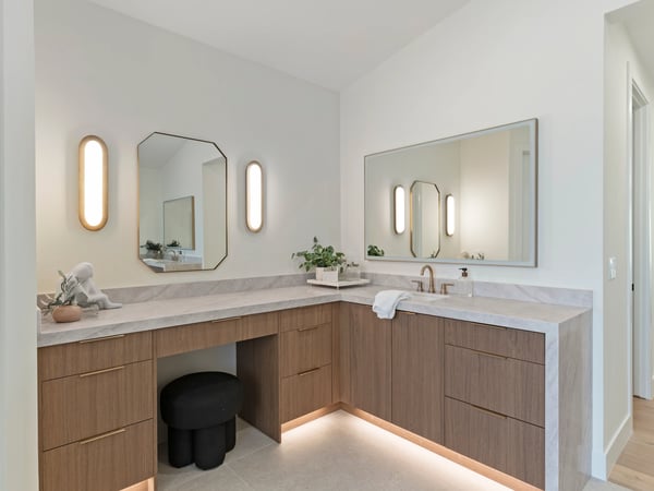 Sophisticated vanity area with custom wood cabinetry, quartz countertops, modern mirrors, and designer lighting. An elegant space offering beauty, storage, and functionality.