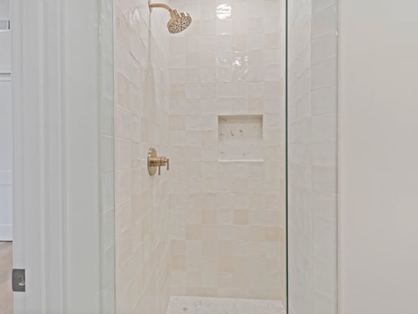 Bright walk-in shower with premium tile finishes, frameless glass, and built-in niche for convenience. This beautifully appointed Scottsdale home offers luxurious bathrooms and designer upgrades.