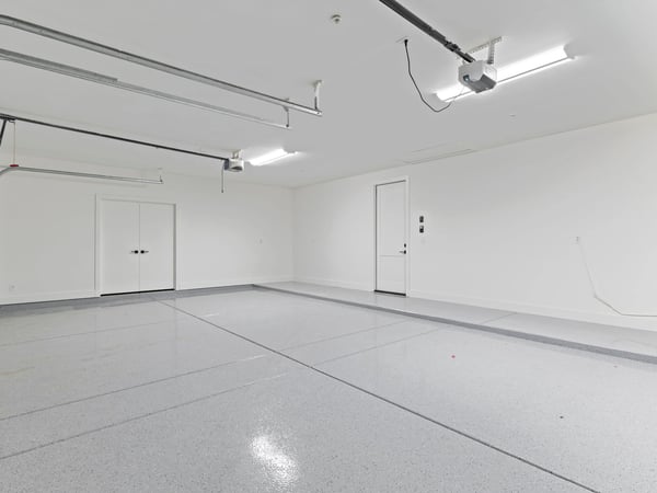 Clean, oversized garage featuring durable epoxy flooring, generous storage space, and room for multiple vehicles. A practical upgrade that enhances everyday living in this Scottsdale property.