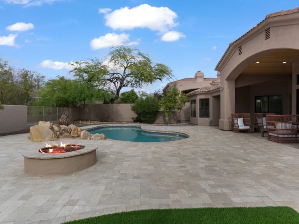 Expansive backyard with a custom fire pit, sparkling pool, spacious entertaining patio, and covered outdoor seating. Designed to maximize Scottsdale's beautiful outdoor lifestyle with luxury amenities.
