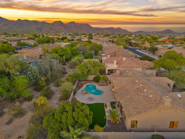 Elevated aerial highlighting the private backyard retreat, resort-style pool, expansive entertaining patio, and bordering desert wash. This Scottsdale property offers peaceful outdoor living and scenic natural surroundings.