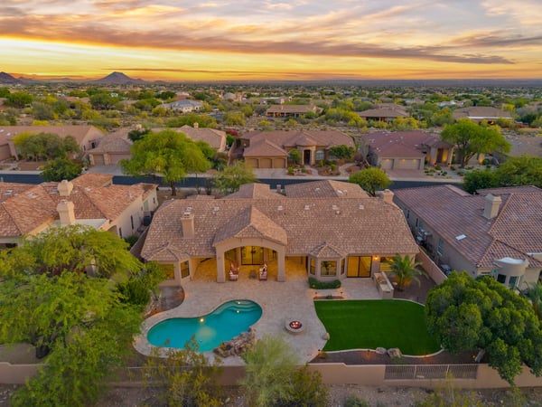 Aerial perspective showcasing the custom pool, fire pit, covered patio, artificial turf, and spacious backyard designed for entertaining. Enjoy resort-inspired living in this Scottsdale home.