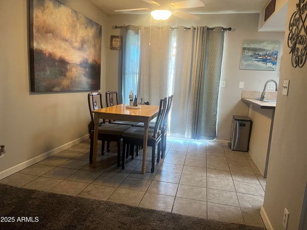 Comfortable dining area offers tile flooring, abundant natural light, and sliding glass doors leading to the private patio for seamless indoor-outdoor living.