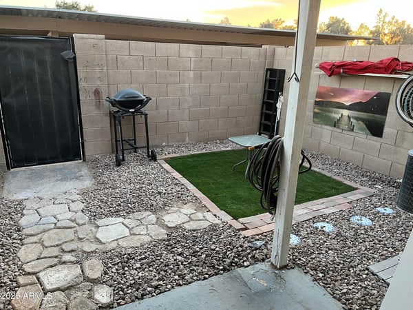 Enjoy a private fenced backyard with a covered patio, artificial turf, decorative rock landscaping, and room for outdoor dining or barbecuing. This low-maintenance outdoor area extends the home's comfortable living space in Glendale.