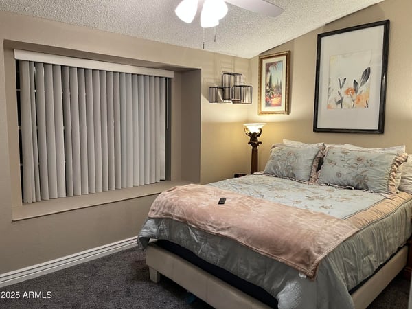 Inviting bedroom features soft carpeting, abundant natural light, a ceiling fan, and neutral d cor that complements any style. This comfortable space provides a relaxing retreat in this well-located Glendale home.