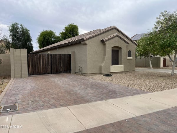 Beautiful front fa ade with a covered entry, attached garage, and mature landscaping welcomes you home with timeless curb appeal and easy-maintenance desert landscaping.