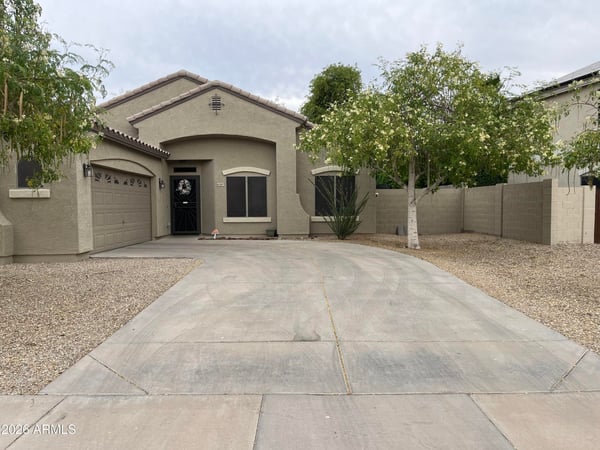 Angled view of the home's exterior highlighting the spacious driveway, RV gate, mature landscaping, and inviting architectural design that enhances this Canyon Trails property
