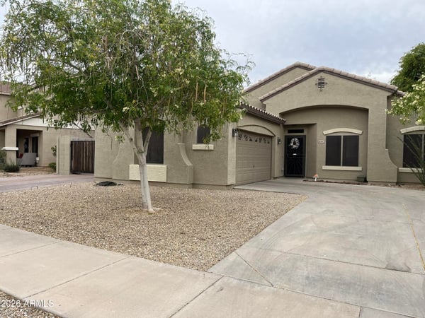 Generous backyard offers a spacious paver patio, grassy area, raised planter beds, and privacy walls, providing endless possibilities for entertaining or outdoor enjoyment.