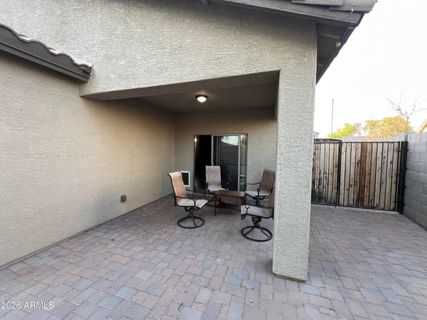 Covered patio creates the perfect shaded outdoor retreat for dining, entertaining, or enjoying quiet evenings while overlooking the spacious backyard.