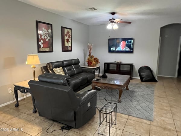 Comfortable great room with neutral finishes, tile flooring, ceiling fan, and an open floor plan designed to accommodate everyday living and entertaining with ease.