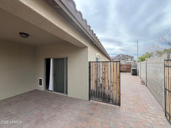 Covered patio opens to an extended paved side yard leading directly to the RV gate, providing excellent accessibility, additional storage options, and low-maintenance outdoor living.