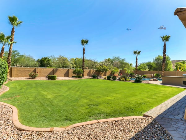 The expansive backyard features an oversized lawn, mature trees, desert landscaping, and abundant space for entertaining or outdoor activities. A private outdoor retreat in this desirable Glendale property.