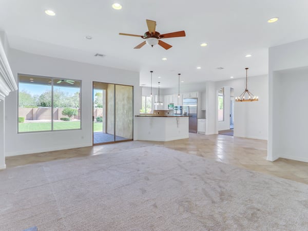 Spacious great room seamlessly connects the kitchen, dining, and living spaces with soaring ceilings, neutral finishes, and abundant natural light. The open layout offers flexibility for entertaining and everyday living.