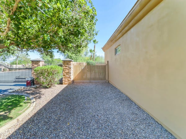 Gated side yard with gravel surface providing convenient RV, trailer, or additional storage access. This Glendale home offers practical outdoor functionality while maintaining attractive landscaping.