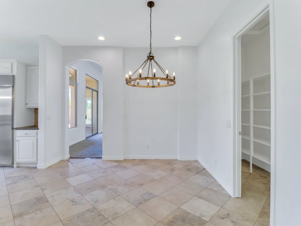 Bright dining area accented by a modern chandelier and surrounded by neutral finishes that complement any d cor. Conveniently located adjacent to the kitchen for easy entertaining and family gatherings.