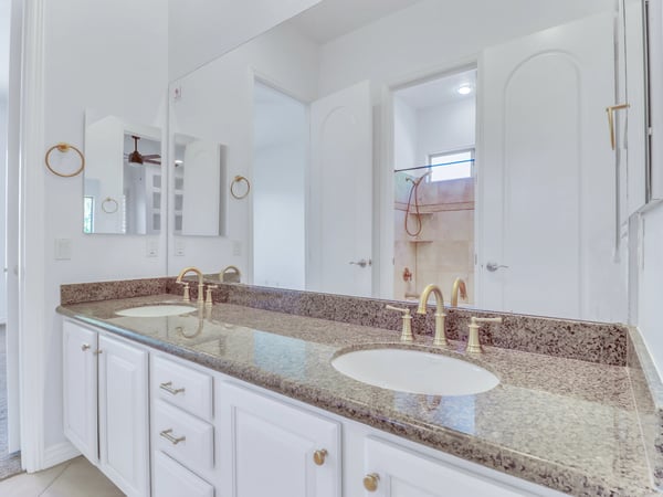 A spacious granite countertop with dual sinks, generous cabinetry, and quality fixtures creates a functional and elegant bathroom. This Glendale home showcases thoughtful design and everyday comfort.