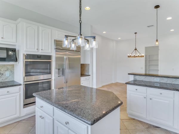 Enjoy preparing meals in a spacious kitchen complete with granite countertops, stainless steel appliances, extensive cabinetry, pendant lighting, and an oversized island. This Glendale home is designed for entertaining.