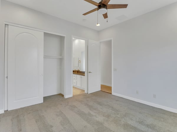 Comfortable bedroom featuring neutral finishes, plush carpet, ceiling fan, spacious closet, and convenient bathroom access. A versatile room ideal for guests, family, or a private office in Glendale.