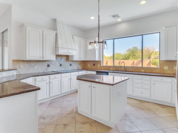 Beautifully designed kitchen with granite countertops, custom cabinetry, center island, decorative range hood, and expansive prep space. This Glendale home combines timeless style with exceptional functionality.
