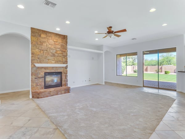 The spacious great room showcases a dramatic floor-to-ceiling stone fireplace, recessed lighting, large windows, and sliding doors opening to the backyard. This Glendale home offers exceptional comfort for everyday living and entertaining.
