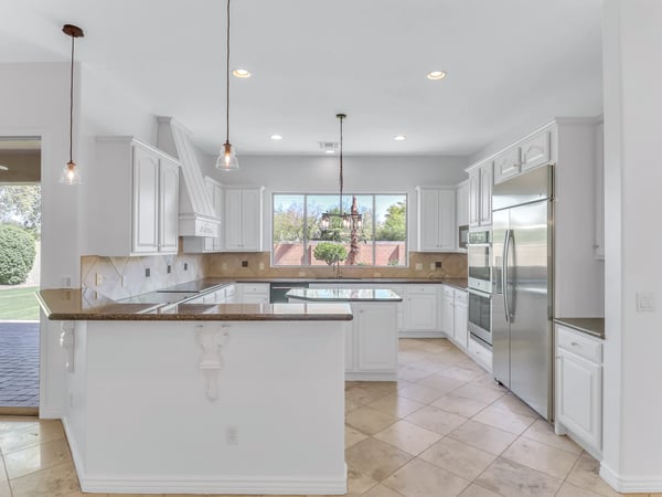 Bright kitchen featuring stainless steel appliances, granite counters, center island, breakfast bar, and abundant cabinetry. Designed for entertaining and everyday living in this beautiful Glendale home.