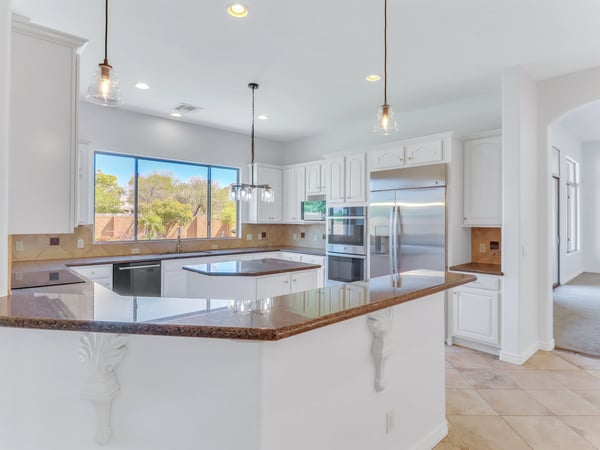 Open kitchen featuring granite countertops, stainless steel appliances, custom cabinetry, center island, pendant lighting, and generous workspace. This Glendale property offers an ideal layout for cooking and entertaining.