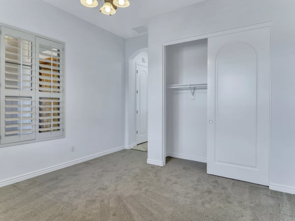 This inviting bedroom offers plush carpeting, plantation shutters, a large closet with sliding doors, and plenty of natural light. Comfortable living spaces enhance the appeal of this Glendale home.
