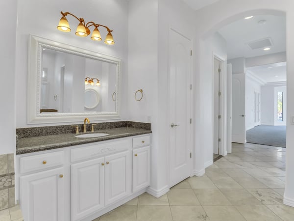 Granite countertops, elegant fixtures, custom cabinetry, and a generous vanity create a functional and stylish bathroom with timeless finishes in this Glendale property.